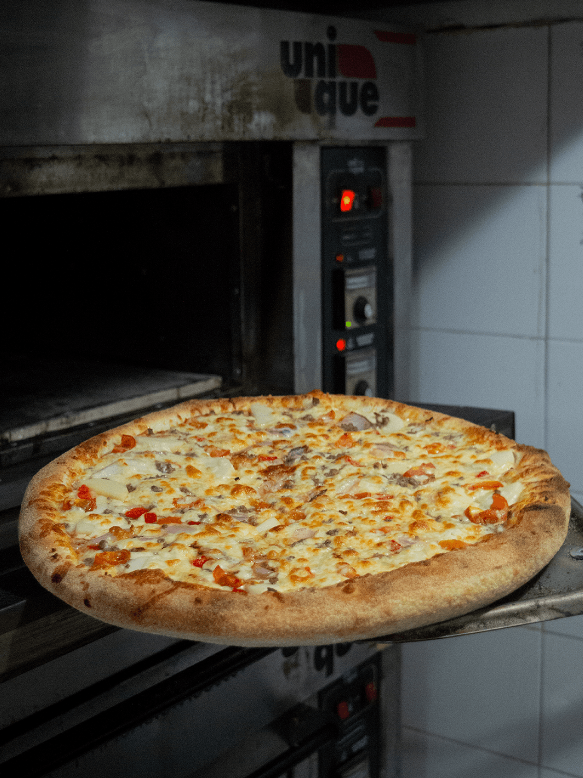 Pizza entrando al horno.